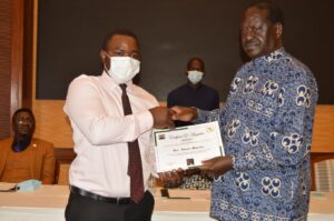 Raila Odinga handing over a certificate
